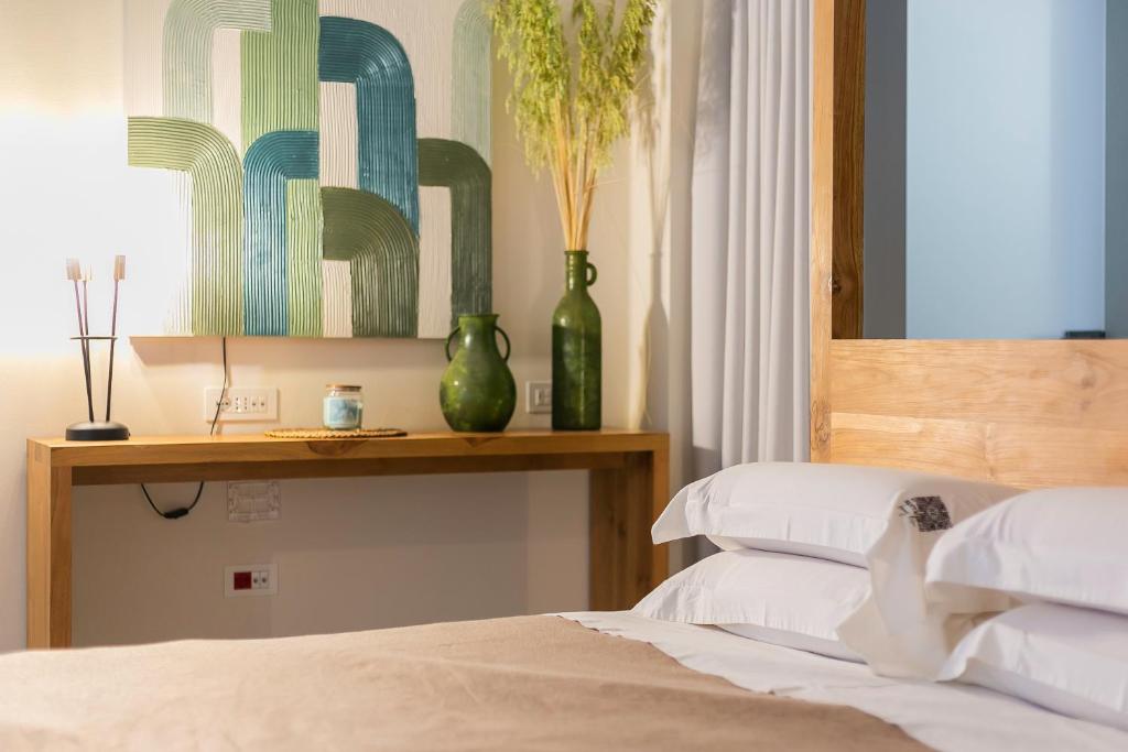 a bedroom with a bed with two green vases on a shelf at Suite 1926 Luxury Room in Triggiano