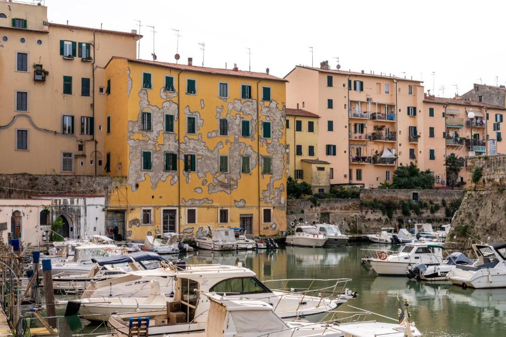 a group of boats docked in a harbor with buildings at Casa Medicea sul canale in Livorno