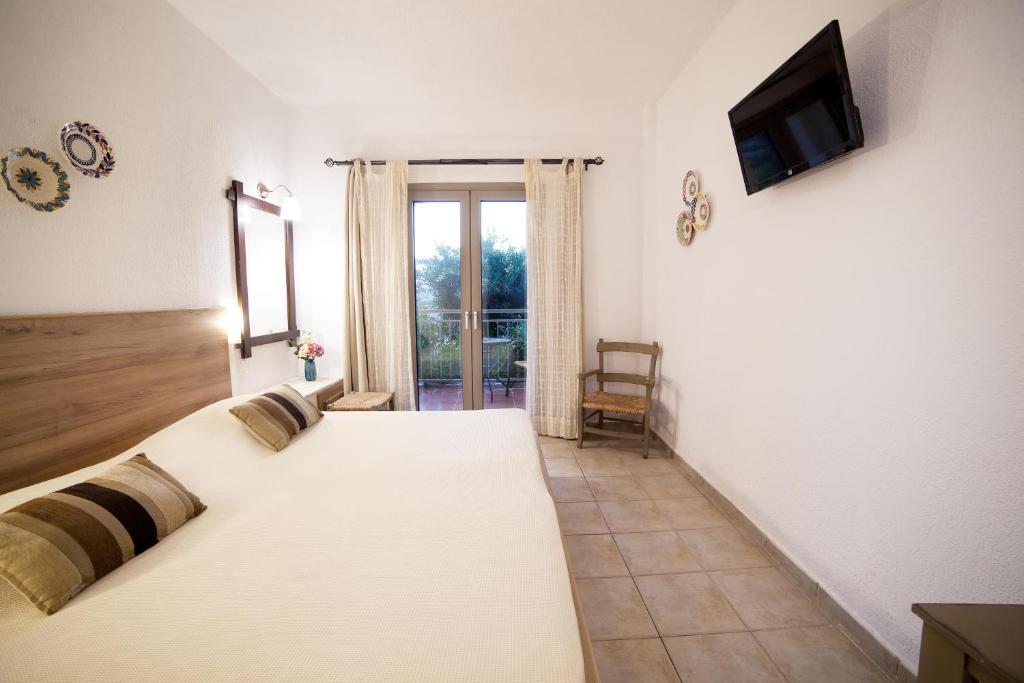 a bedroom with a large bed with a tv on the wall at Elpida Village in Istro