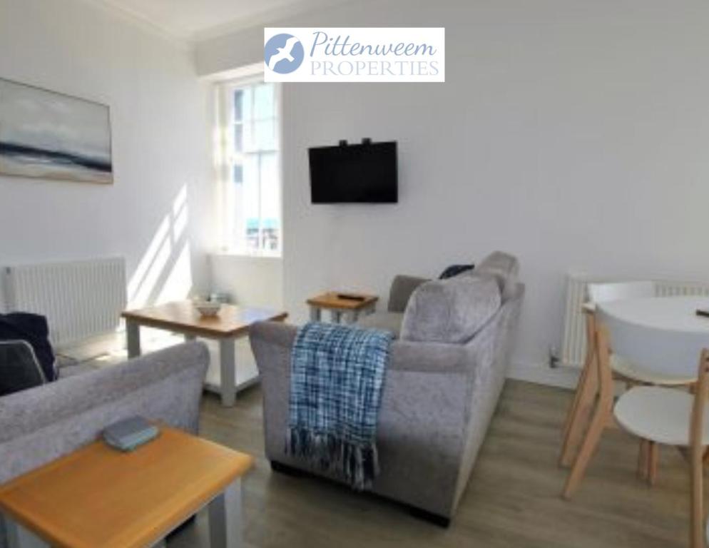 a living room with a couch and a table at May View in Pittenweem