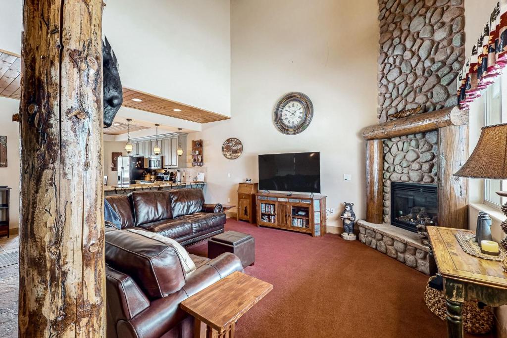 a living room with a leather couch and a fireplace at Steps to Brian Head Resort: Ski Home w/ Games in Brian Head