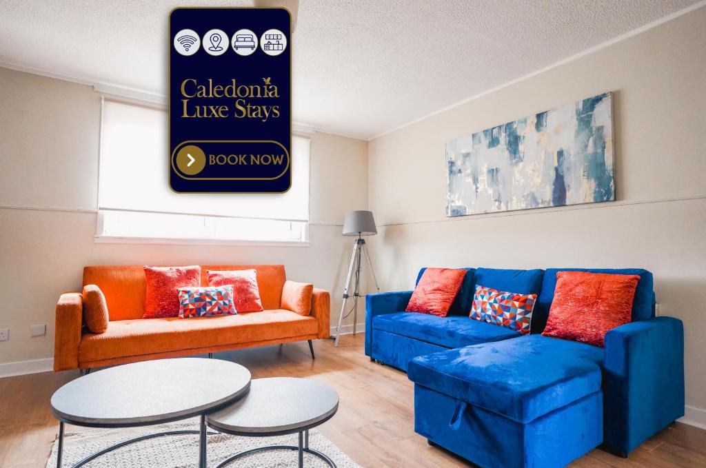 a living room with two blue couches and a table at North Elgin Apartment in Clydebank