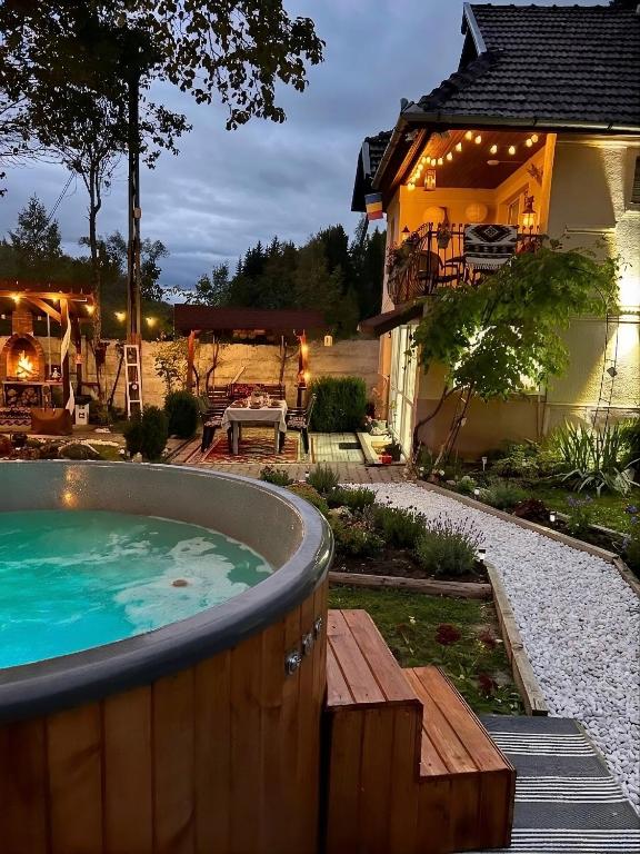 a hot tub in a yard next to a house at BraziHouse - pine escape with jacuzzi in Petroşani