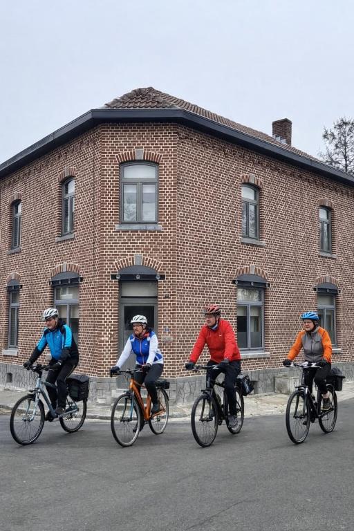 a group of people riding bikes in front of a brick building at Vakantiewoning Bij de Jep in Bilzen