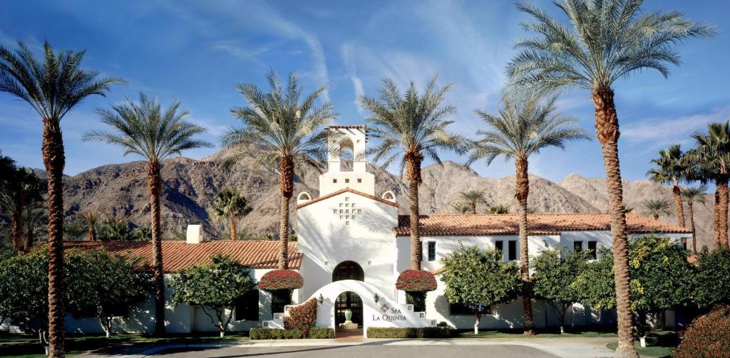 a building with palm trees in front of a mountain at La Quinta Resort & Club in La Quinta