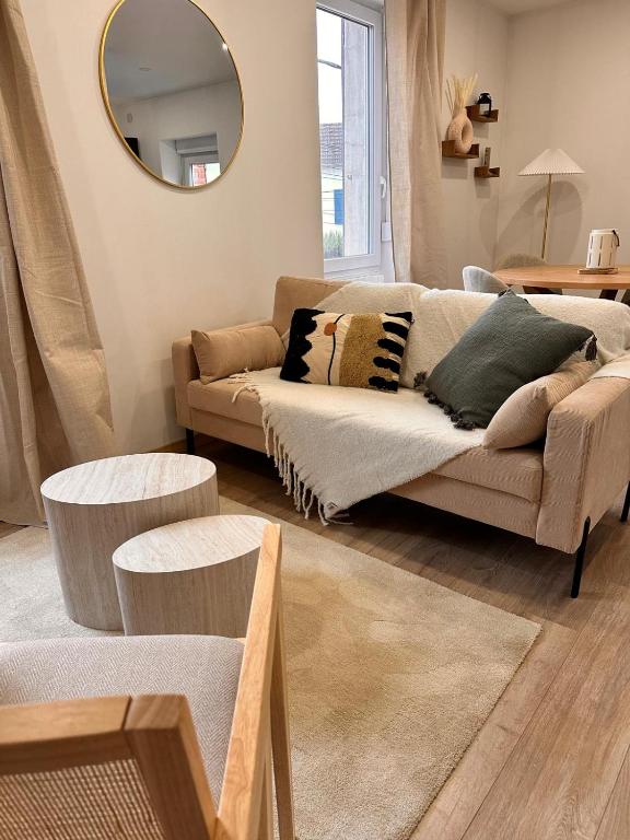 a living room with a couch and a mirror at Savane 2 bedrooms and private parking in Vesoul