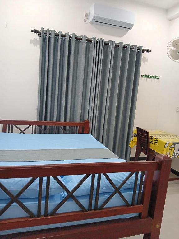 a room with a bed and a gray curtain at Sanda Villa Dodanduwa in Dodanduwa