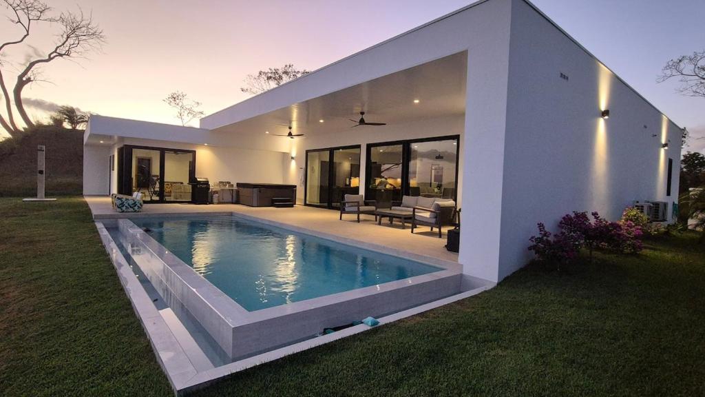 a house with a swimming pool in the backyard at Stunning seaside villa with pool and jacuzzi in Boca Chica
