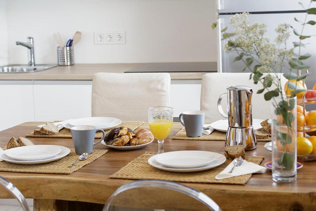 una mesa de madera con platos y vasos de zumo de naranja en Ganexa Home, en Zarautz