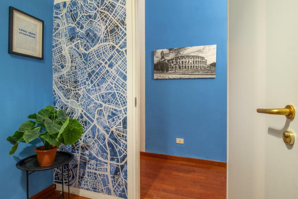 a hallway with a blue wall with a painting on it at Long John Apartment in Rome