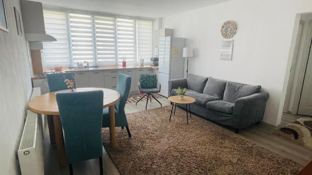 a kitchen and a living room with a table and a couch at Boulevard apartament in Sighetu Marmaţiei