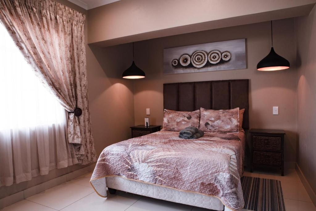 a bedroom with a large bed and a window at Rusty Estate - Self Catering in eMalahleni