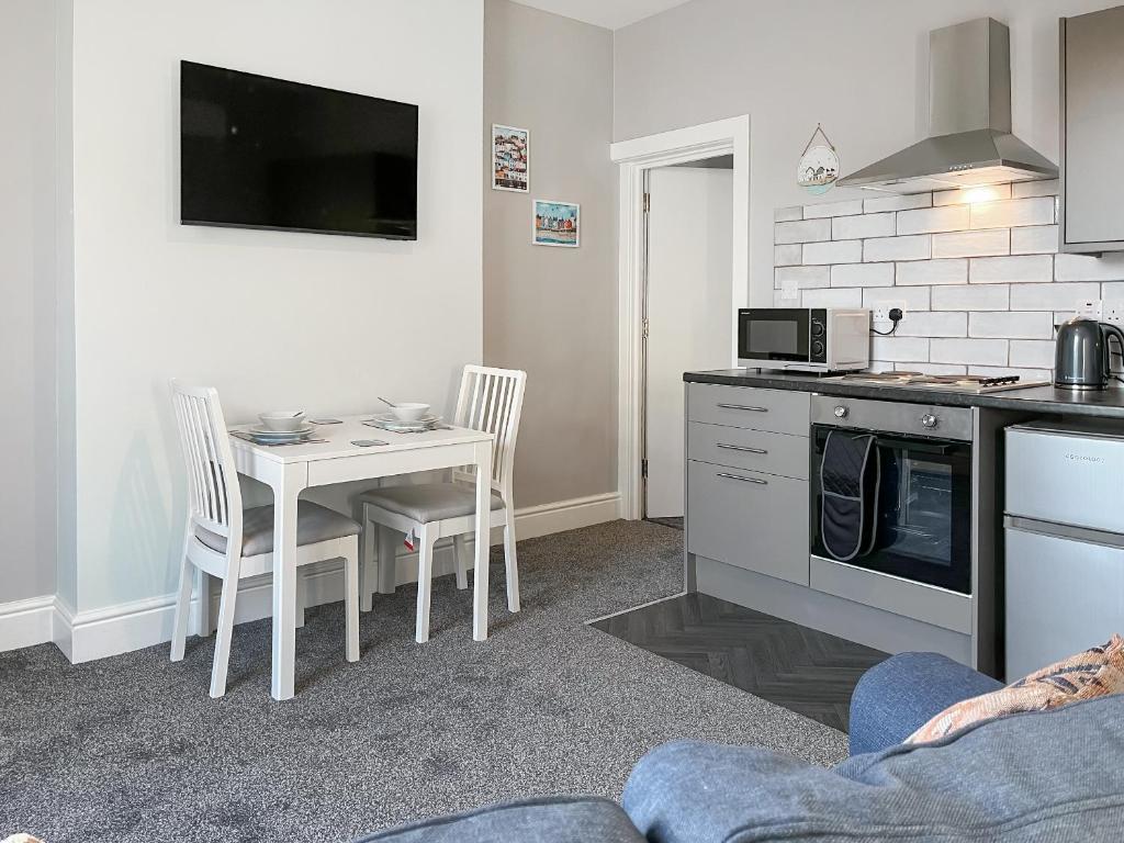 a kitchen with a table and a table and chairs at Rose - Uk49363 in Bridlington