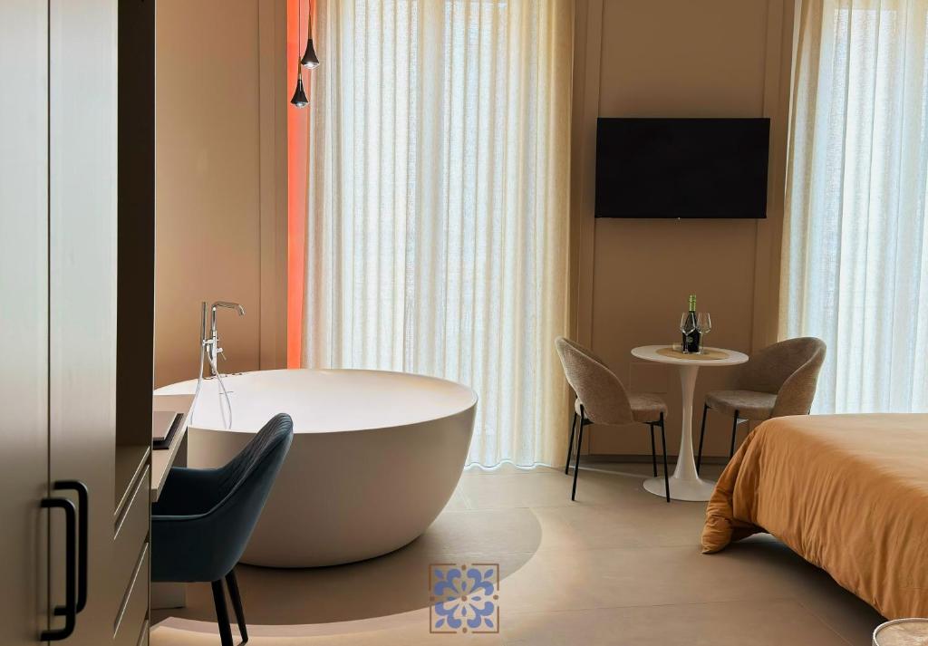 a hotel room with a tub and a bed at Passo Lento Charme Rooms in Gravina in Puglia