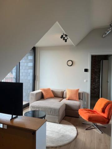 a living room with a couch and a chair at Bomaison charmant landelijke studio in Aalter