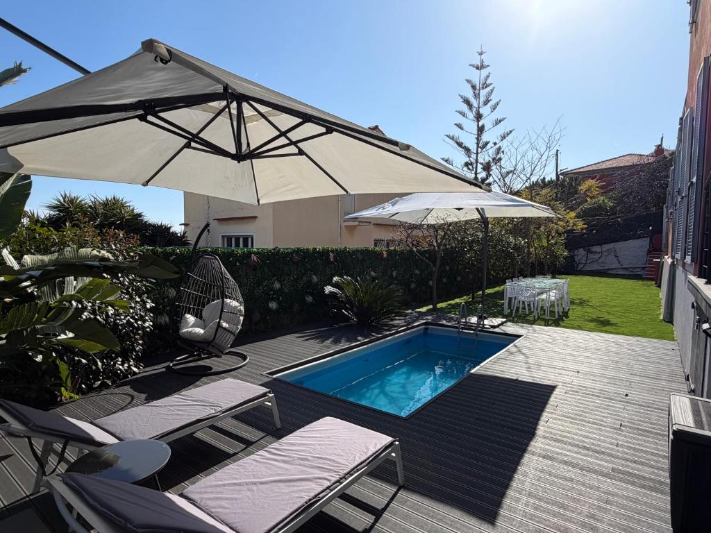 a patio with an umbrella and a swimming pool at MyBlueVista LUXURY SEA VIEW PRIVATE VILLA CAP D AIL 200M MONACO in Cap d'Ail