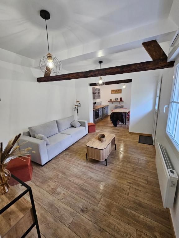 a living room with a white couch and a table at Gite Le Reposoir Argoules in Argoules