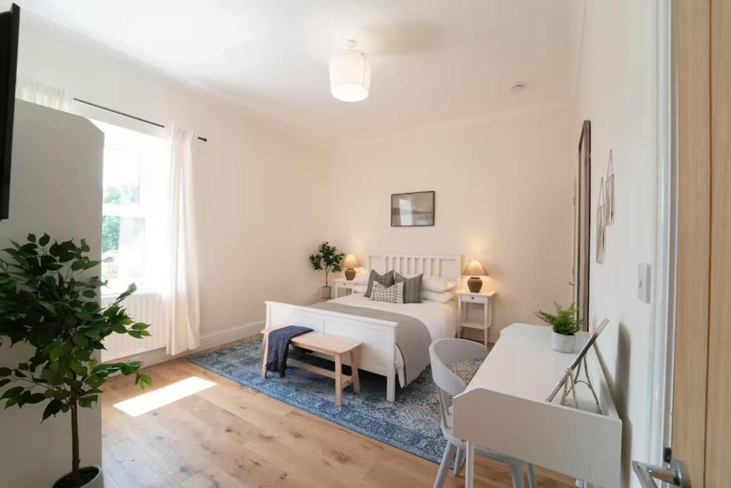a living room with a white bed and a table at Foundry Farm Apartment in Hexham