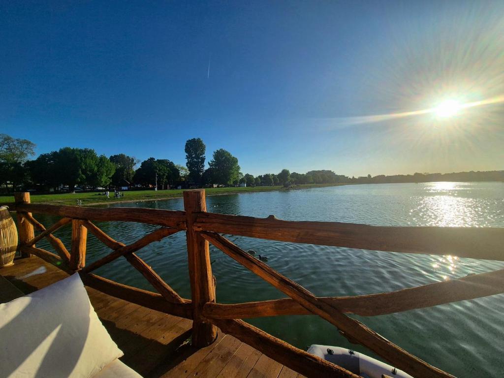 a wooden fence next to a body of water at Domček na vode 5 in Senec
