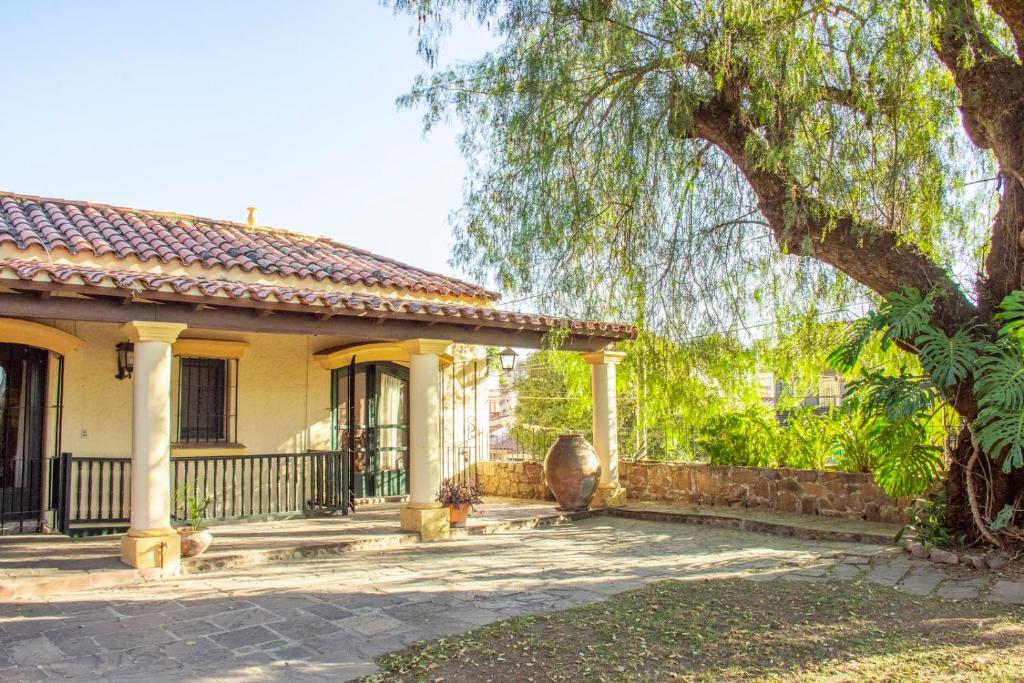 a yellow house with a fence and a tree at Casona Don Roque in Salta