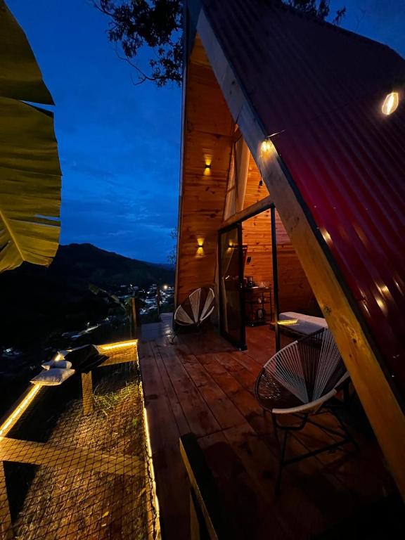a house with a deck with two chairs and lights at Glamping Villa JuanMa in Salónica