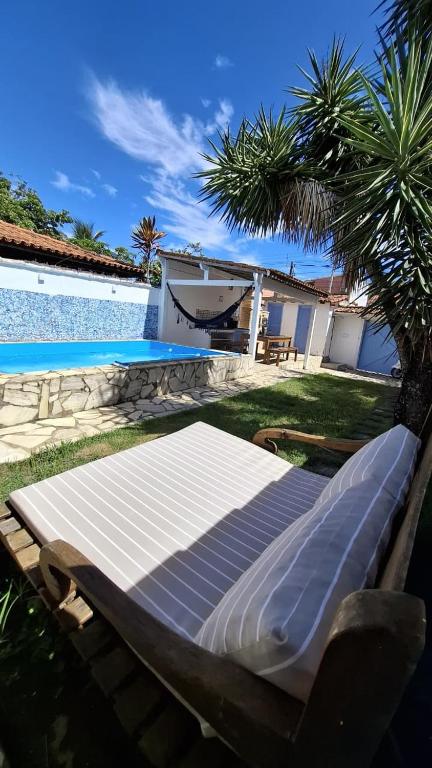 a mattress laying on the grass next to a swimming pool at El refugio in Búzios