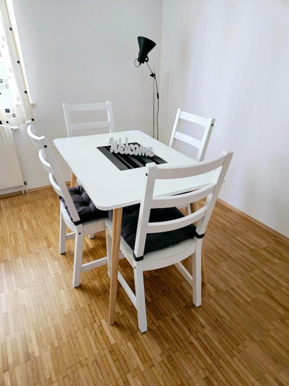 a white dining room table with four chairs and a lamp at Cozy, new, central in Graz