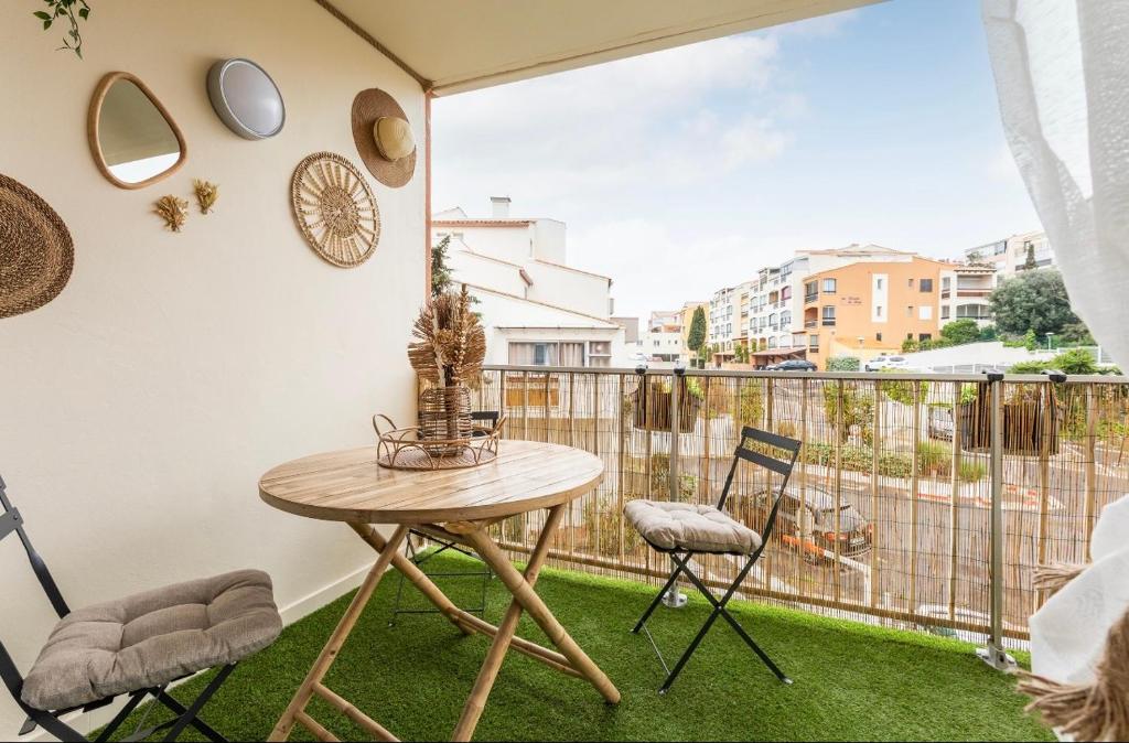 a balcony with a table and two chairs and a window at Studio La perle clim balcon parking privé in Cap d'Agde