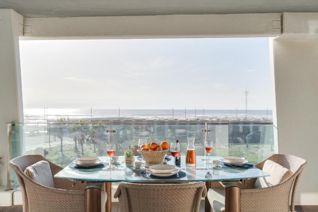 a table with a bowl of fruit and wine glasses at luxury Plazza Sea view in Costa da Caparica