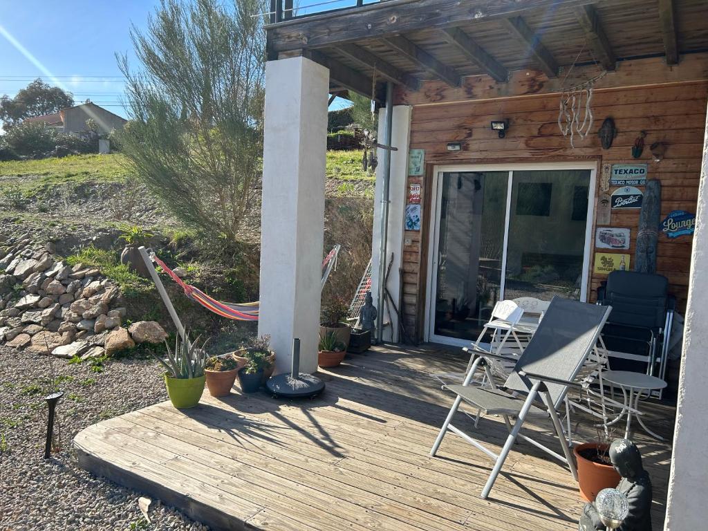 a porch of a cabin with chairs and a table at Le studio de St Martin in Saint-Martin-de-lʼArçon