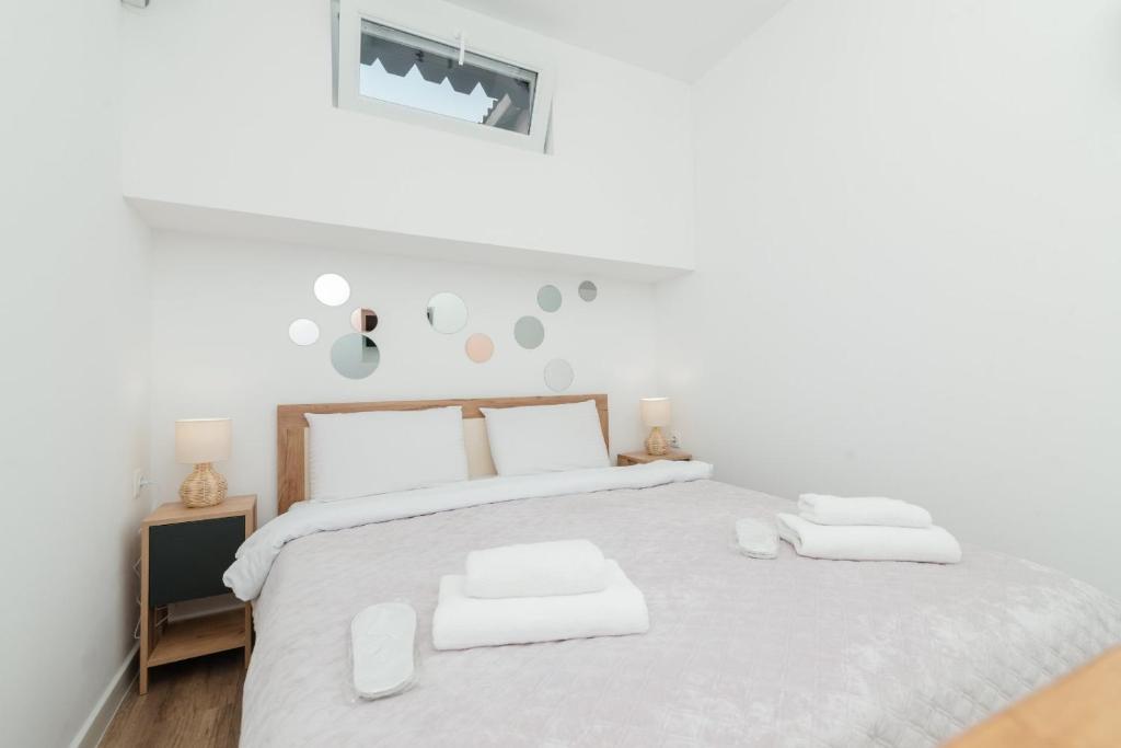 ein weißes Schlafzimmer mit einem großen Bett und zwei weißen Handtüchern. in der Unterkunft ERA Studios 4 in Chişinău