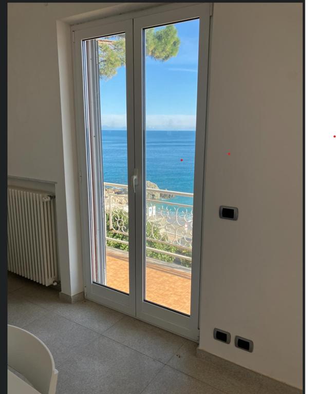 a room with a sliding glass door with a view of the ocean at Verdazzurra in Bergeggi