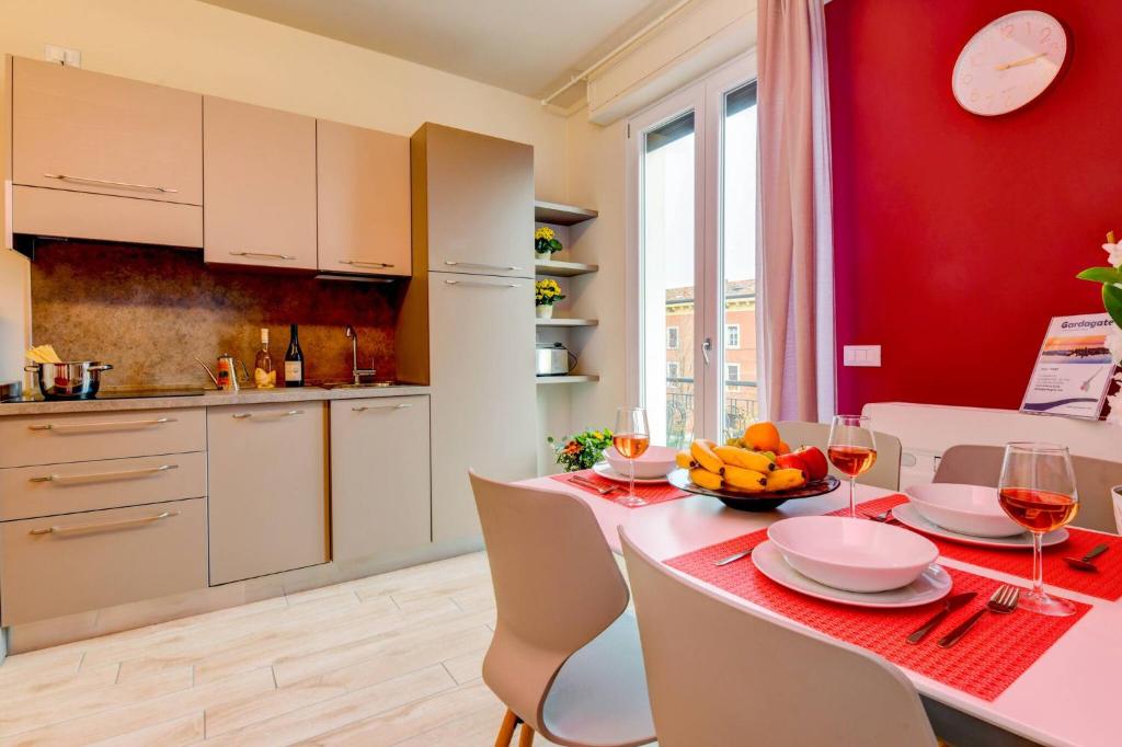 a kitchen with a table with a red wall at Casa Vino - Gardagate in Salò