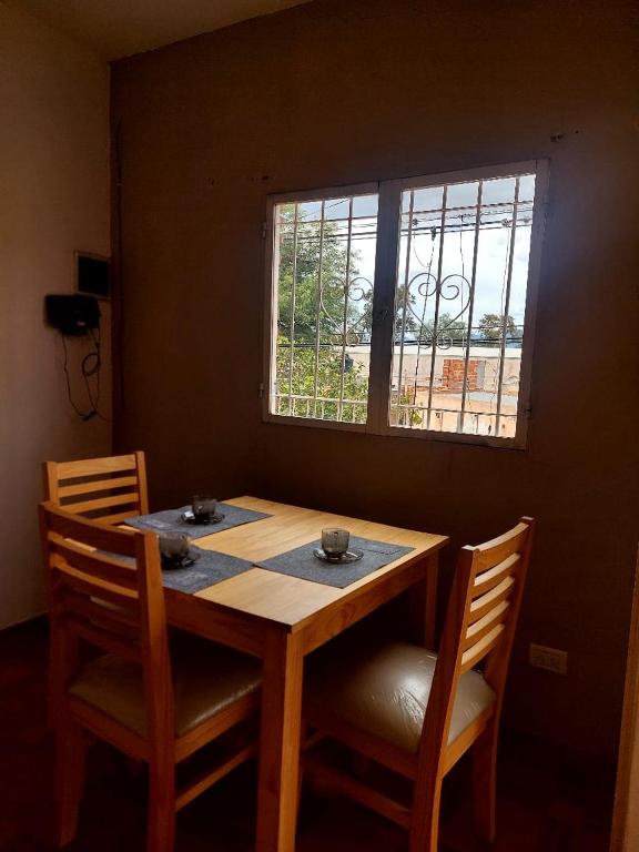 a wooden table with two chairs and a window at Cactus del Valle 2 in Tinogasta
