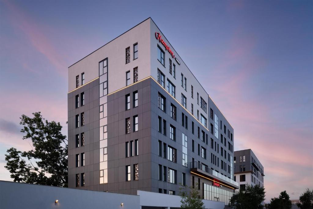 a tall gray building with a sign on it at Hampton By Hilton Targu Mures in Târgu-Mureş