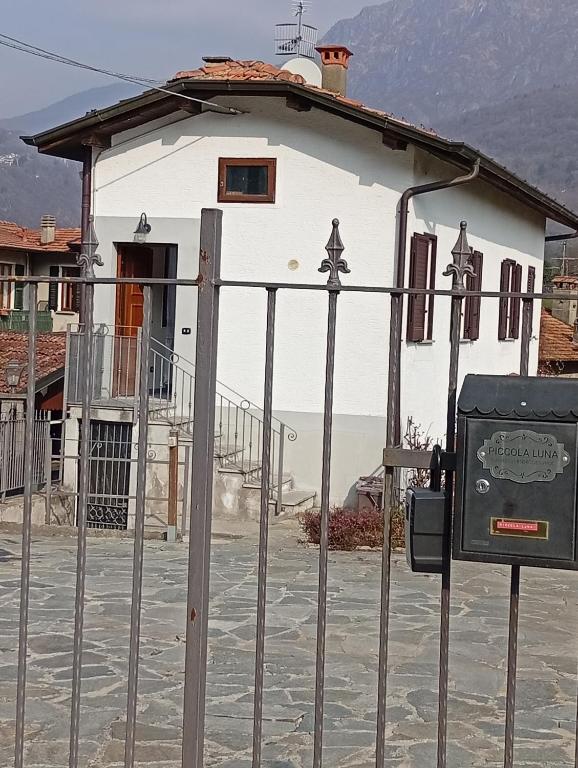 a white building with a fence in front of it at Piccola Luna in Menaggio