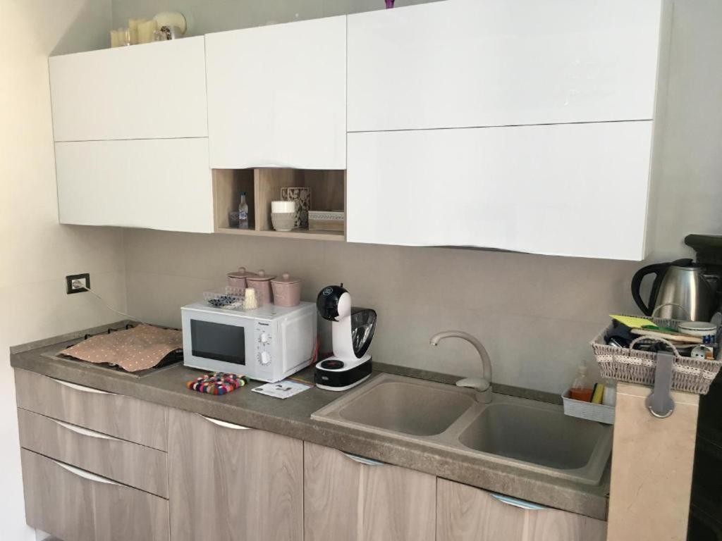 a kitchen with a sink and a microwave at Le Dimore di Mariuccia 1 in Monte SantʼAngelo