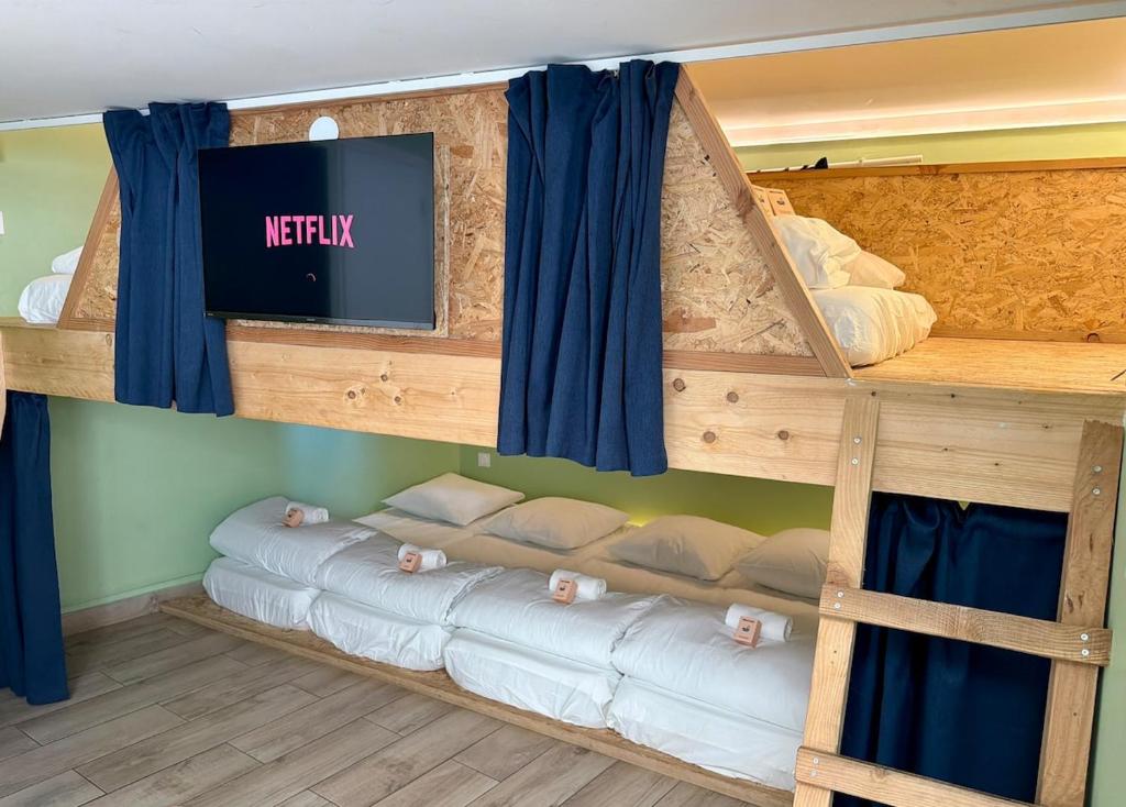 a bunk bed with three beds in a room at Sleep and Go Lyon Oullins in Oullins