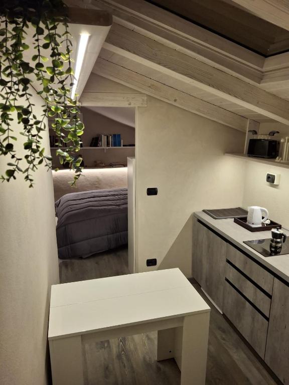 a kitchen with a table and a bed in a room at Il Nido della Piazzetta in Saluzzo