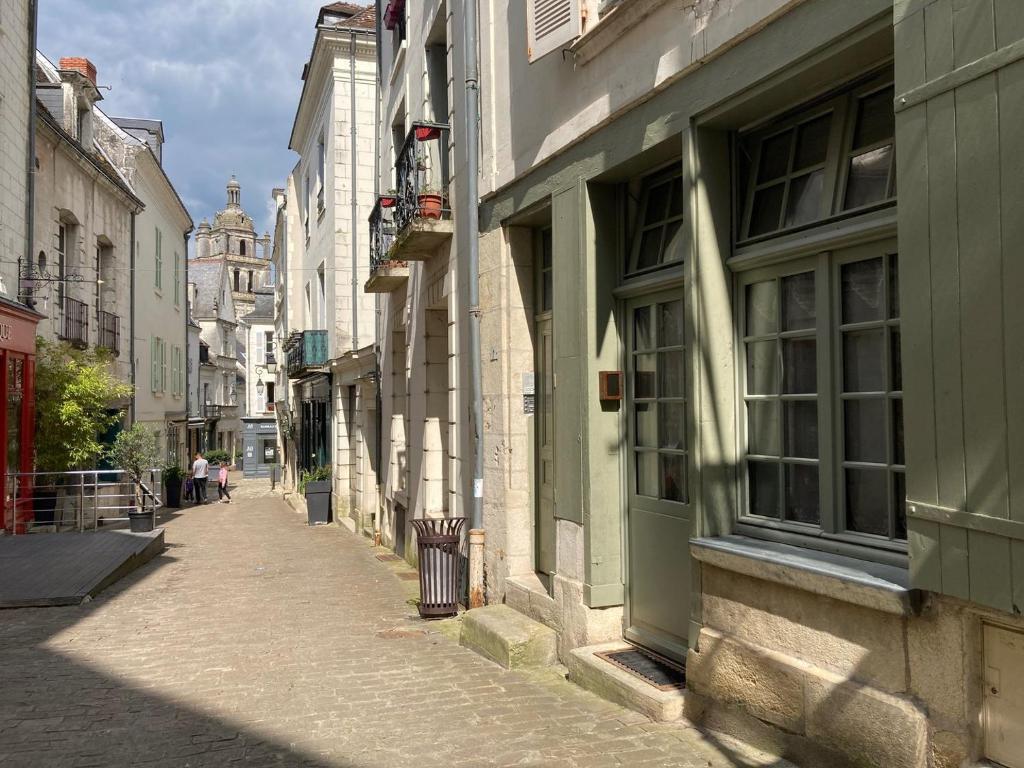 an alley in a city with people walking down the street at La Chancellerie in Loches