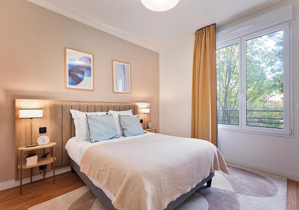 a bedroom with a large bed and a window at Zenao Appart'hôtels Saint-Mandé in Saint-Mandé