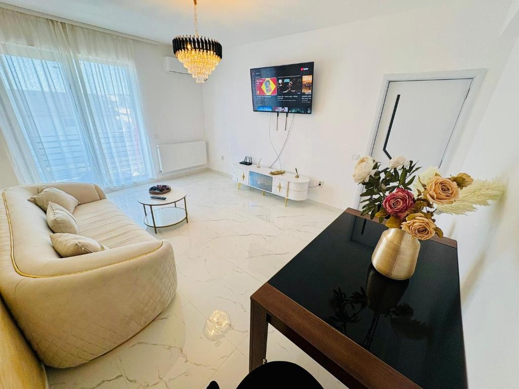 a living room with a couch and a table at Atlantis Suites Bragadiru Bucuresti Parcare gratuita Self checkin in Bragadiru