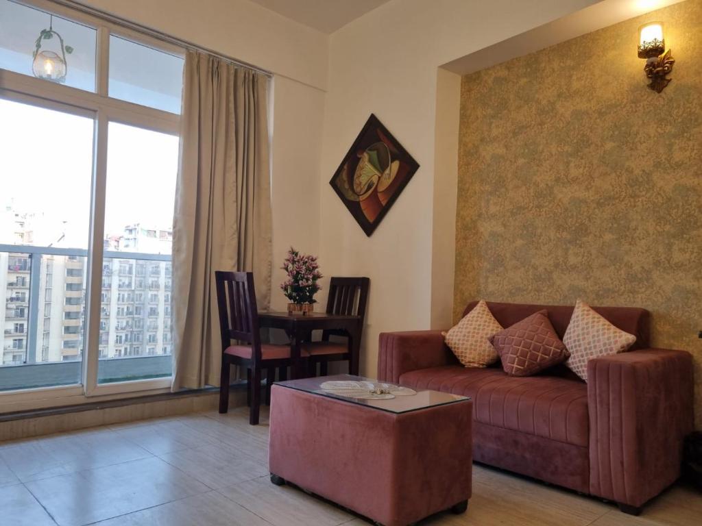 a living room with a couch and a table at Tranquil Homes in Noida