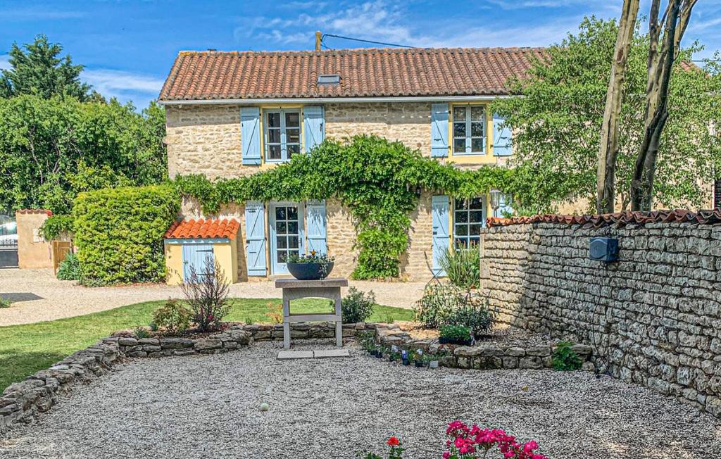 a brick house with a stone wall and a yard at Maison du Figuier 1799 in Nanclars
