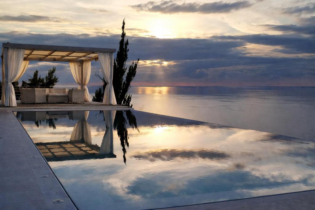 a reflection of the sky in a pool of water at Okeanos Vine Luxury Villa in Athani