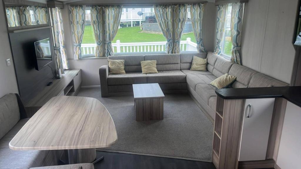 a living room with a couch and a table at Caravan- Sleeps 6 2 Bedrooms - Thurston Manor in Dunbar
