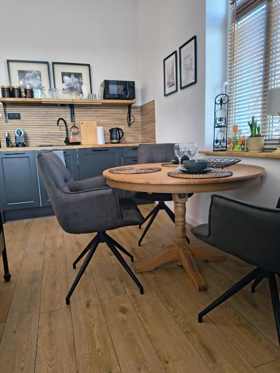 a table and chairs in a kitchen with a counter at Apartament Wieżyczka in Świdnica