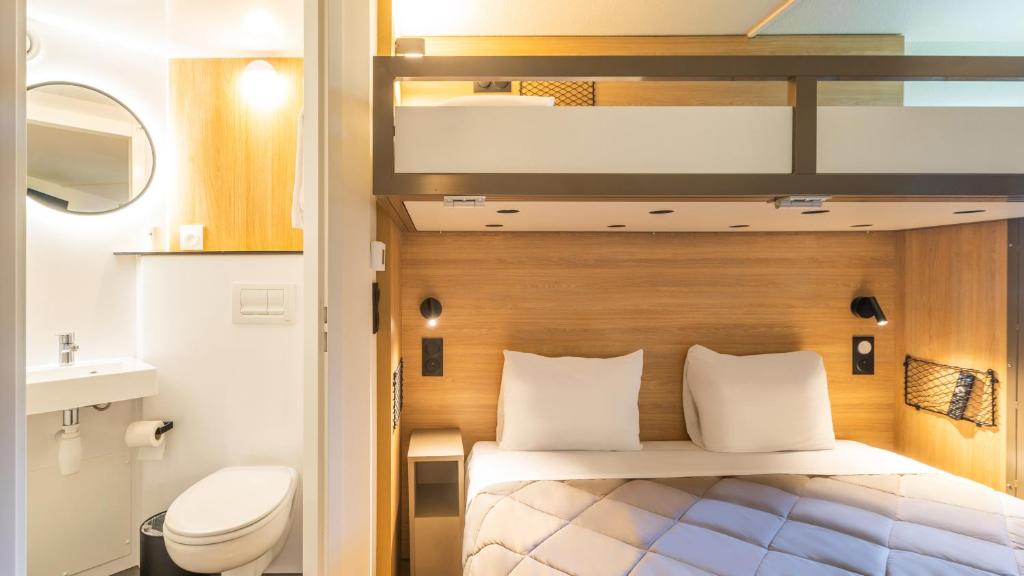 a small room with a bed and a toilet at Premiere Classe Orleans Nord - Saran in Saran