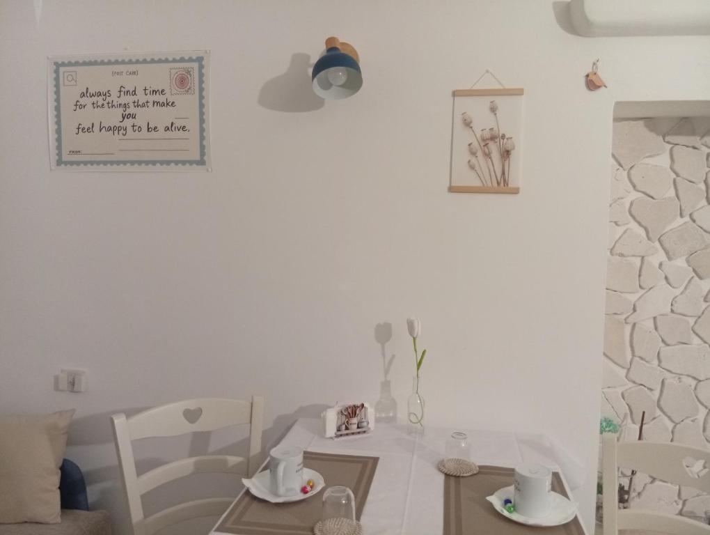 a white dining room with a table and chairs at CV MiRa house in Putignano