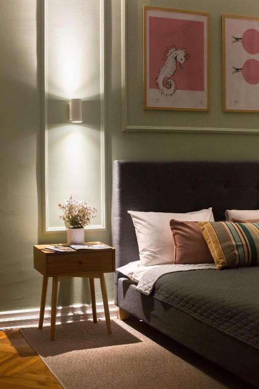 a bedroom with a bed and a nightstand with a table at High Note Suites in Belgrade